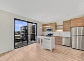 Thumbnail 1 of 107 - A modern kitchen with a white table and a refrigerator.