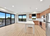Thumbnail 95 of 107 - A modern kitchen with a table and chairs in the middle of the room.