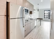 Thumbnail 64 of 107 - A modern kitchen with a stainless steel refrigerator and wooden cabinets.