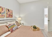 Thumbnail 75 of 107 - A bedroom with a bed, two lamps, a basket of flowers, and two paintings on the wall.