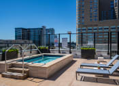 Thumbnail 6 of 24 - the pool on the rooftop of a building with a city in the background