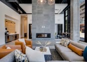 Thumbnail 10 of 24 - a living room with a gray couch and a fireplace