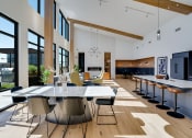 Thumbnail 11 of 24 - a large dining room with a table and chairs and a kitchen with a large window
