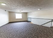 Thumbnail 12 of 13 - A room with a carpeted floor and a window.