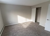 Thumbnail 7 of 13 - A room with a carpeted floor and a door leading to another room.