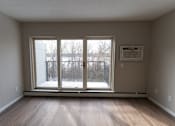 Thumbnail 6 of 13 - A room with a sliding glass door leading to a snowy outdoor area.