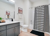 Thumbnail 22 of 24 - a bathroom with a black and white shower curtain and a toilet