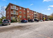 Thumbnail 5 of 53 - a parking lot in front of a brick apartment building