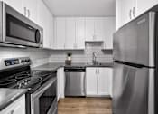 Thumbnail 18 of 53 - a kitchen with white cabinets and stainless steel appliances
