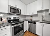 Thumbnail 13 of 53 - a kitchen with white cabinets and stainless steel appliances