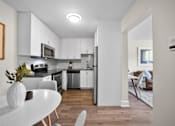 Thumbnail 21 of 53 - a kitchen with white cabinetry and black countertops