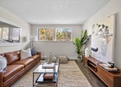 Thumbnail 8 of 53 - a living room with a brown leather couch and a glass coffee table