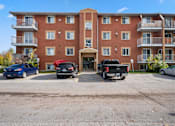 Thumbnail 4 of 53 - a large brick building with a parking lot in front of it