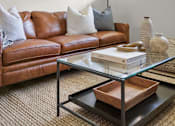 Thumbnail 7 of 53 - a living room with a brown leather couch and a glass coffee table