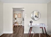 Thumbnail 25 of 53 - a dining area with a table and chairs and a round mirror on the wall