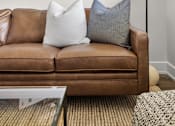 Thumbnail 15 of 53 - a living room with a brown couch and a white lamp