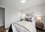 Thumbnail 42 of 53 - a bedroom with a bed and a nightstand with a lamp