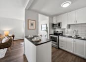 Thumbnail 49 of 53 - a kitchen with white cabinets and a black counter top