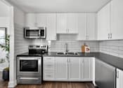 Thumbnail 52 of 53 - a kitchen with white cabinets and stainless steel appliances