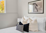 Thumbnail 16 of 53 - a bedroom with a large bed with white sheets and black and white pillows