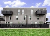 Thumbnail 19 of 22 - A grey building with black railings and windows.