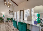 Thumbnail 27 of 46 - a dining room with green chairs and a white table and a desk with a lamp