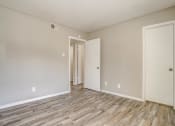 Thumbnail 39 of 46 - an empty living room with wood flooring and white walls