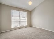 Thumbnail 37 of 46 - an empty living room with a large window and carpet