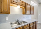 Thumbnail 33 of 46 - a kitchen with a sink and wooden cabinets