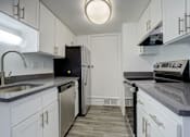Thumbnail 4 of 31 - a kitchen with white cabinets and a sink and a refrigerator