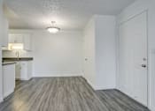 Thumbnail 14 of 31 - an empty living room and kitchen with white walls and wood flooring