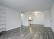 Thumbnail 15 of 31 - an empty living room with white walls and wood flooring