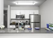 Thumbnail 4 of 17 - a kitchen with a counter top and a stove top oven