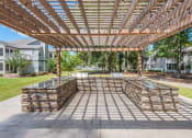 Thumbnail 17 of 20 - an outdoor patio with a wooden pergola and stone walls
