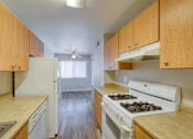 Thumbnail 14 of 17 - a kitchen with white appliances and wooden cabinets