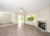 Thumbnail 7 of 17 - a living room with a fireplace and a ceiling fan
