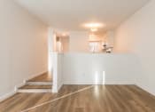 Thumbnail 21 of 25 - a living room and dining room with hardwood floors and a kitchen in the background