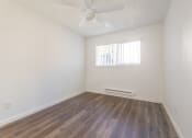 Thumbnail 16 of 25 - a bedroom with hardwood floors and a ceiling fan