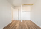 Thumbnail 14 of 25 - a bedroom with hardwood floors and white walls
