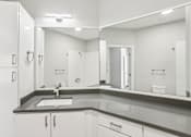 Thumbnail 17 of 35 - A bathroom with a sink and mirror.