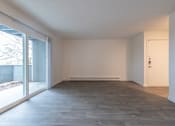 Thumbnail 17 of 41 - an empty living room in a house with a large sliding glass door