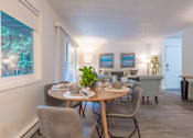 Thumbnail 9 of 41 - a dining area with a table and chairs and a living room in the background