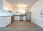 Thumbnail 8 of 41 - a kitchen with white cabinets and a wood floor