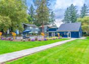 Thumbnail 1 of 25 - a sidewalk leading to a blue house with a pool in the front and trees in the background