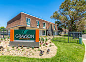 Thumbnail 1 of 36 - a green and orange sign in front of a brick building