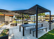 Thumbnail 22 of 36 - a picnic table and bench under awning on a concrete patio