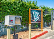 Thumbnail 34 of 36 - a sign with a map and a ticket machine in front of a hedge