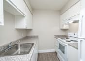 Thumbnail 12 of 36 - a kitchen with white appliances and granite countertops