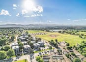 Thumbnail 1 of 22 - A sunny day in a residential area with houses and greenery.