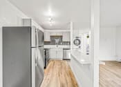 Thumbnail 29 of 42 - a kitchen with white cabinets and a wooden floor